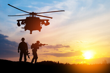 Plakat Silhouettes of helicopter and soldiers on background of sunset.