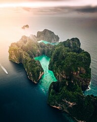 Fototapeta premium Aerial view of a forested green rocky island with a sandy beach in Thailand, Krabi, Phi Phi Island