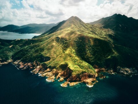 Aerial view of a green hill and coastline in Sai Kung in sunshine