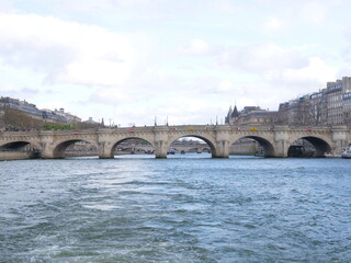 A view from a boat of the Seine river on a cloudy day. 