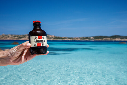 bottiglia mignon di birra Ichnusa sullo sfondo di uno splendido mare cristallino della Sardegna