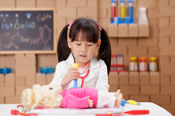 A little girl with doctor s coat pretend be a doctor and playing educational medical game