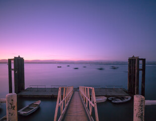 Beautiful view of a calm sea from a pier during pink sunset