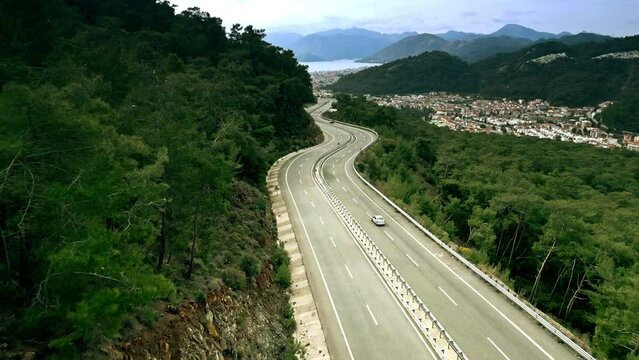 Aerial view of a mountain winding road and distant city of Marmaris, Turkey