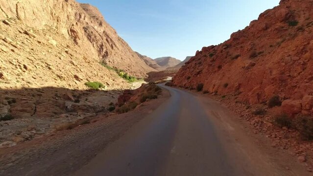 POV of a driver along a solitary road and riads in the moroccan Atlas