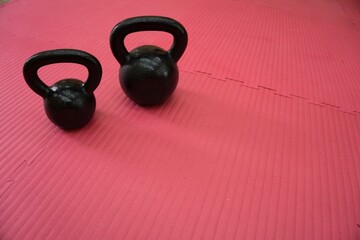 Fitness kettle bells on a red carpet
