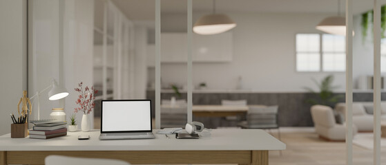 Modern white home office workspace with laptop mockup and accessories on table