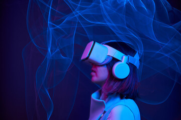 Woman is using virtual reality headset to access in metaverse.