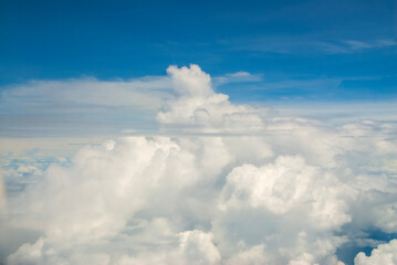 Fluffy clouds. Beautiful dramatic sunset sky above fluffy clouds in early morning from aerial drone view. Traveling by air. View from an airplane window. Aerial view of Malaysia.White clouds floating 