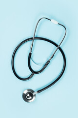 Black stethoscope for doctor diagnostic coronavirus disease, medical tool for health on blue background with copy space
