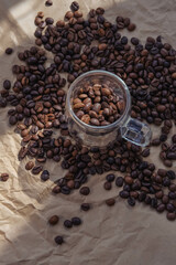 Coffee beans in glass jar on crumpled paper background