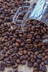 Fototapeta premium Coffee beans in glass jar on crumpled paper background
