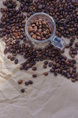 Coffee beans in glass jar on crumpled paper background