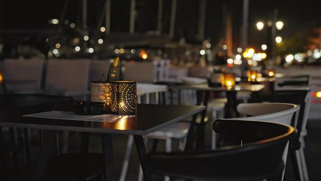 Beautiful vintage lamp Shimmering orange light of bright scenery blurred night in restaurant stands on wooden table at sunset. Travel. Tourism