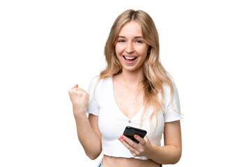 Young English woman over isolated background with phone in victory position