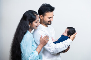 Portrait of Indian parents with newborn baby, Young asian couple holding little baby in hand. Beautiful family. Parenthood.