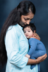 Young indian mother with cute newborn baby in her arms. Motherhood. 