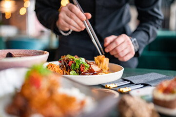Obraz na płótnie Canvas chef hands decorated food on plate