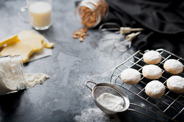 Traditional arabian cookies (kahk) sprinkled with white sugar and it's ingredients (flour, milk, butter, sugar and nuts)

