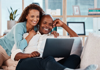 Laptop, relax and a couple watching a movie on a sofa in the living room of their home together for entertainment. Computer, video or streaming with a man and woman enjoying a series while bonding