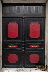The door of the historical inn painted black and red. Old inn doors made in the Ottoman period. Istanbul historical inn gates.