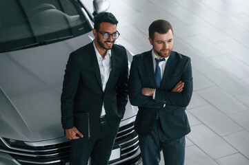 Fototapeta premium View from the top. Two businessmen are working together in the car showroom
