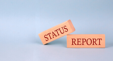STATUS REPORT text on the wooden block, blue background