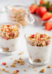 Fototapeta na wymiar Morning dessert strawberry granola with light yogurt in white kitchen.
