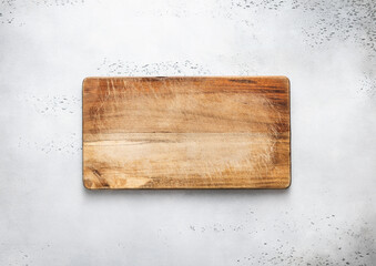 Empty scratched wooden cutting chopping kitchen board on light background.Top view.