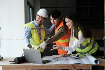 Team of engineers working on a personal computer at a metallurgical workshop.