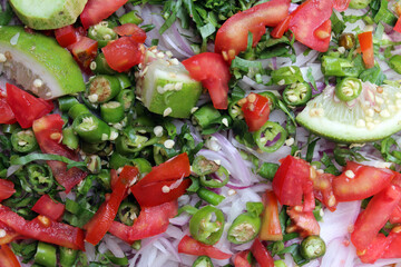 Healthy vegetable salad of fresh tomato, cucumber, onion, Green chilies, red Chilies . Diet menu. Salad Background with tomato, onions, cucumber, chilies and Lemon।