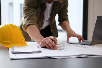 architect man working with laptop and blueprints,engineer inspection in workplace for architectural...