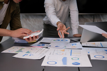 Teamwork of asian business people discussing and calculating with calculator on evaluation data in conference room. with the growth and pointing to the chart graph financial account.