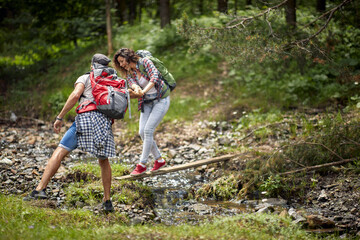 Naklejka na ściany i meble Happy avanturistic traveler couple hiking together