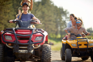 Young people ride quads on a road in the nature.