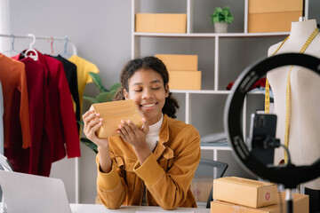 African American female sell box product online live streaming at home.