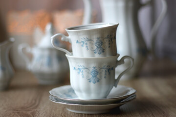 Vintage white tea set with pale blue flowers. Selective focus.