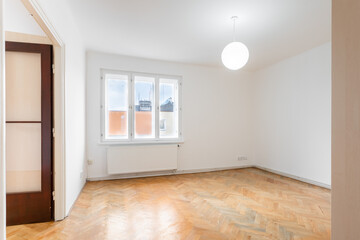 Fototapeta na wymiar an empty room in an apartment with a wardrobe and a wooden parquet floor
