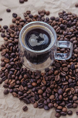Coffee beans and a cup of coffee on brown paper background