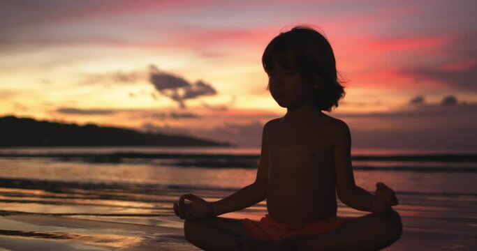 Silhouette little dreamer sitting in lotus position and meditating