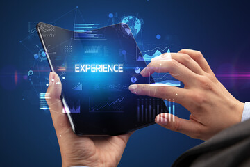 Businessman holding a foldable smartphone, business concept