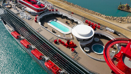 Aerial view of a large cruise ship docked at the port. There is no one on board and the ship is...