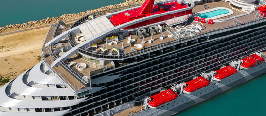 Aerial view of a large cruise ship docked at the port. There is no one on board and the ship is...