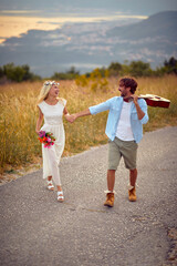 Happy newlyweds walking the road in the nature. Relationship, honeymoon, nature