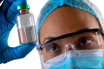 Female health worker wearing face mask holding covid-19 vaccine bottle against white background