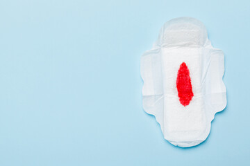 Women hygiene products or Sanitary pad with red feather on colored background. Pastel color. Closeup. Empty place for text. Female daily hygiene © sosiukin
