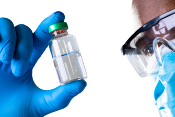 Close up of african american male health worker wearing face mask holding covid-19 vaccine bottle