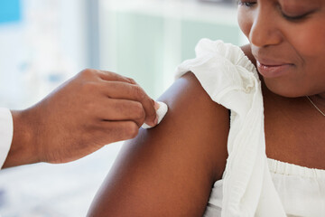 Doctor cleaning the patient arm before an injection in a consultation room in the hospital. Healthcare, hygiene and hand of medical worker wipe the skin before a vaccine in a medicare clinic.