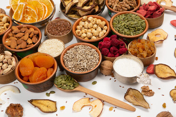 Healthy vegetarian food concept. Assortment of dried fruits, nuts and seeds on white background. Top view. Mixed nuts set closeup.