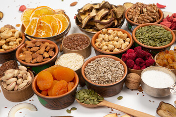 Healthy vegetarian food concept. Assortment of dried fruits, nuts and seeds on white background. Top view. Mixed nuts set closeup.